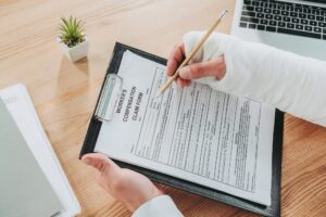 Injured worker signing up workers compensation claim form.