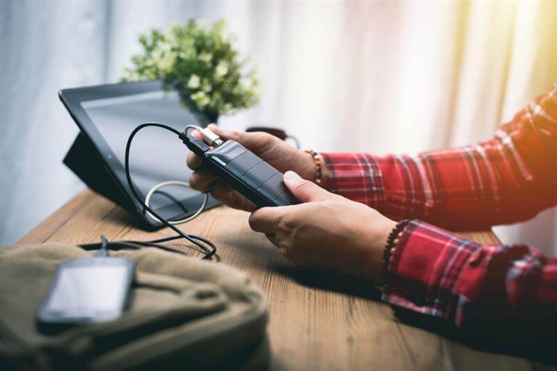 Young man's phone charging through powerbank.