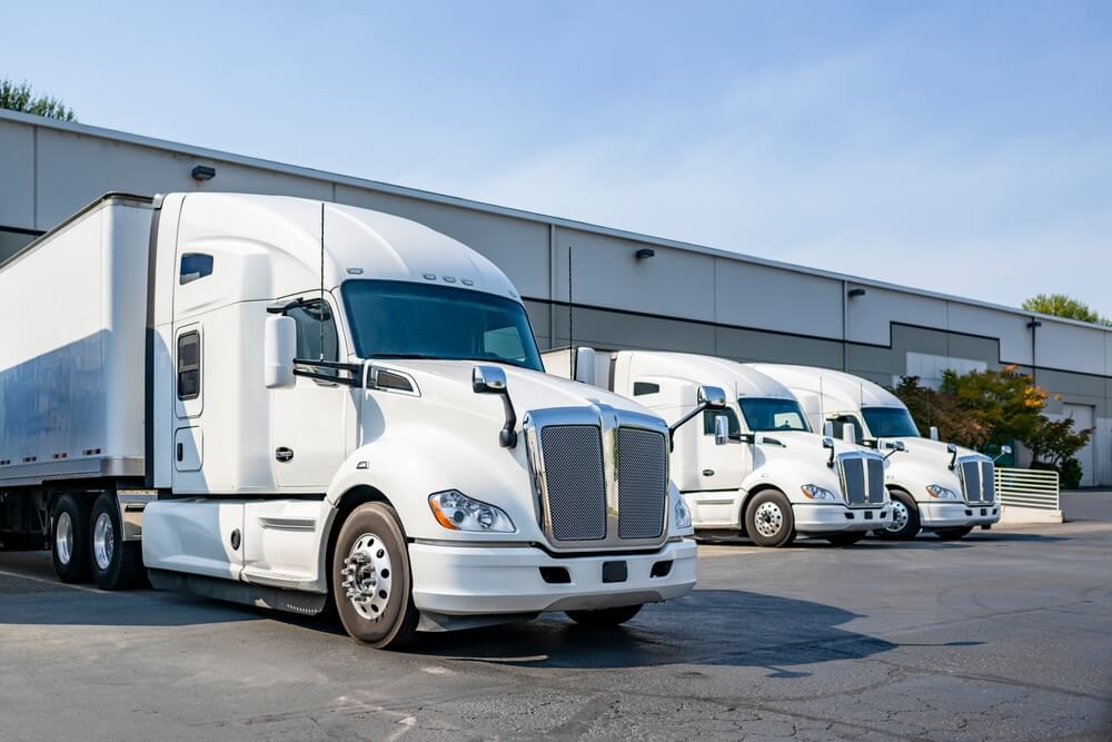 White big rig trucks for delivery on parking.