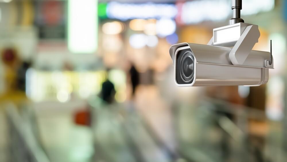 Retail security surveillance, CCTV camera monitors customers and public areas inside a shopping center to prevent theft and improve safety.